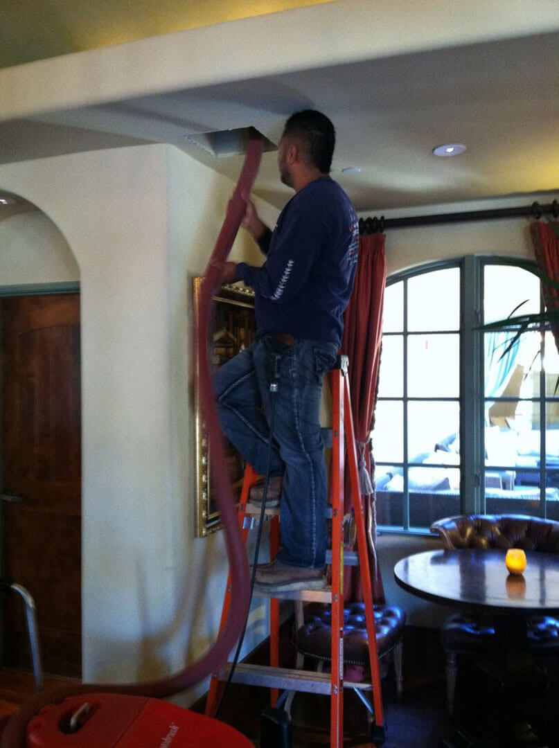 HVAC technician in Morgan Hill cleaning air ducts